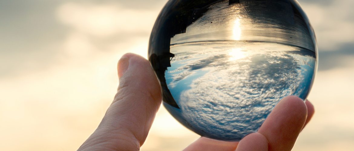 Sky in crystal ball in hand